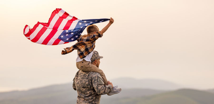 A military man with a child and a flag